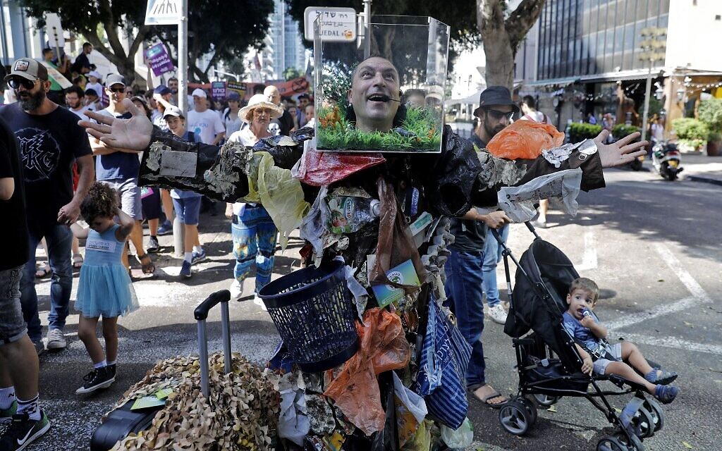 Des militants et des manifestants israéliens tiennent des pancartes pendant une manifestation mondiale contre l'inaction en matière de changement climatique dans la ville côtière israélienne de Tel Aviv, le 27 septembre 2019. (Crédit : AHMAD GHARABLI/AFP)