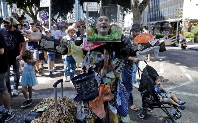 Des militants et des manifestants israéliens tiennent des pancartes pendant une manifestation mondiale contre l'inaction en matière de changement climatique dans la ville côtière israélienne de Tel Aviv, le 27 septembre 2019. (Crédit : AHMAD GHARABLI/AFP)