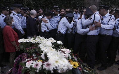 Des policiers israéliens pleurent leur collègue tué, le policier chrétien Amir Khoury, lors de ses funérailles à Nof Hagalil, le jeudi 31 mars 2022. (Crédit : AP Photo/Ariel Schalit)
