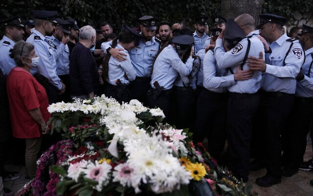 Des policiers israéliens pleurent leur collègue tué, le policier chrétien Amir Khoury, lors de ses funérailles à Nof Hagalil, le jeudi 31 mars 2022. (Crédit : AP Photo/Ariel Schalit)