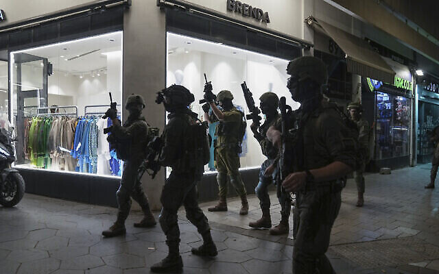 Les forces de l'ordre israéliennes recherchent des assaillants près des lieux d’un attentat terroriste à Tel-Aviv, Israël, le 7 avril 2022. (Crédit : AP Photo/Ariel Schalit) Les forces de l'ordre israéliennes recherchent des assaillants près des lieux d’un attentat terroriste à Tel-Aviv, Israël, le 7 avril 2022. (Crédit : AP Photo/Ariel Schalit)