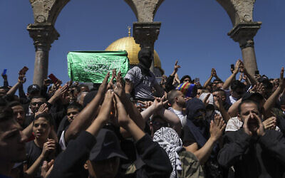 Des Palestiniens scandant des slogans et agitant des drapeaux du Hamas lors d'une manifestation contre Israël, devant le Dôme du Rocher, dans l'enceinte de la mosquée Al-Aqsa, au sommet du mont du Temple, dans la Vieille Ville de Jérusalem, le 15 avril 2022. (Crédit : AP Photo/Mahmoud Illean)