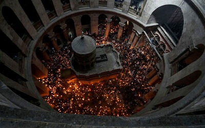 Des pèlerins chrétiens tiennent des bougies alors qu'ils se rassemblent pendant la cérémonie du feu sacré à l'église du Saint-Sépulcre, dans la Vieille Ville de Jérusalem, samedi 23 avril 2022. (Crédit : AP Photo/Maya Alleruzzo)