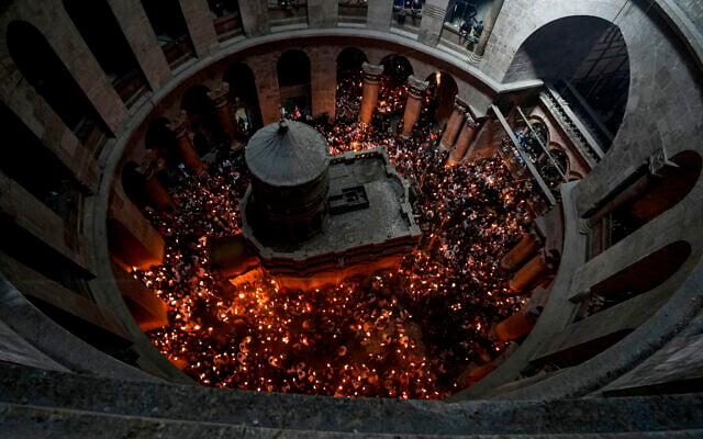 Des pèlerins chrétiens tiennent des bougies alors qu'ils se rassemblent pendant la cérémonie du feu sacré à l'église du Saint-Sépulcre, dans la Vieille Ville de Jérusalem, samedi 23 avril 2022. (Crédit : AP Photo/Maya Alleruzzo) Des pèlerins chrétiens tiennent des bougies alors qu'ils se rassemblent pendant la cérémonie du feu sacré à l'église du Saint-Sépulcre, dans la Vieille Ville de Jérusalem, samedi 23 avril 2022. (Crédit : AP Photo/Maya Alleruzzo)