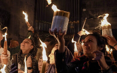 Des pèlerins chrétiens tiennent des bougies alors qu'ils se rassemblent pendant la cérémonie du feu sacré à l'église du Saint-Sépulcre, dans la Vieille Ville de Jérusalem, samedi 23 avril 2022. (Crédit : AP Photo/Maya Alleruzzo)