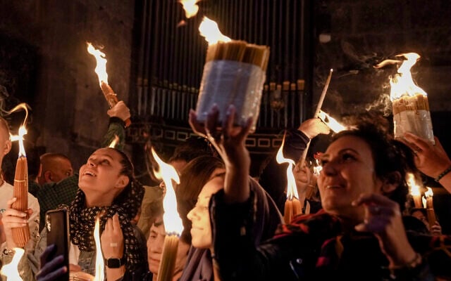 Des pèlerins chrétiens tiennent des bougies alors qu'ils se rassemblent pendant la cérémonie du feu sacré à l'église du Saint-Sépulcre, dans la Vieille Ville de Jérusalem, samedi 23 avril 2022. (Crédit : AP Photo/Maya Alleruzzo) Des pèlerins chrétiens tiennent des bougies alors qu'ils se rassemblent pendant la cérémonie du feu sacré à l'église du Saint-Sépulcre, dans la Vieille Ville de Jérusalem, samedi 23 avril 2022. (Crédit : AP Photo/Maya Alleruzzo)