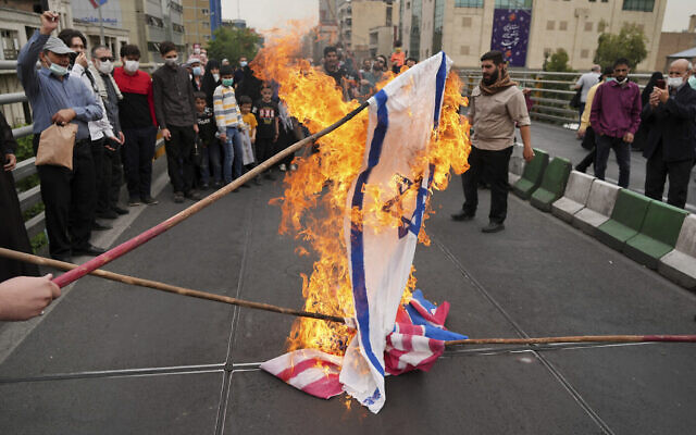 Des manifestants brûlent des représentations de drapeaux israélien, britannique et américain lors du rassemblement annuel pro-palestinien de la Journée d'Al-Quds, à Téhéran, en Iran, le vendredi 29 avril 2022. (Crédit : AP Photo/Vahid Salemi) Des manifestants brûlent des représentations de drapeaux israélien, britannique et américain lors du rassemblement annuel pro-palestinien de la Journée d'Al-Quds, à Téhéran, en Iran, le vendredi 29 avril 2022. (Crédit : AP Photo/Vahid Salemi)