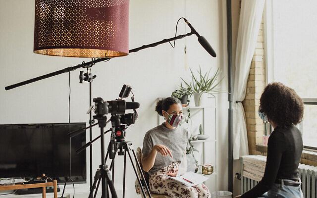La réalisatrice Sara Yacobi-Harris interviewe Sarah Aklilu pendant le tournage de Periphery, une partie de l’exposition du même nom à UJA Toronto. (Crédit : Liat Aharoni)