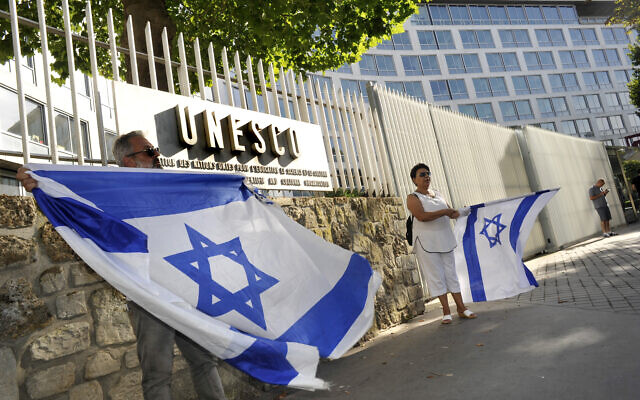 Des Juifs français tiennent des drapeaux israéliens, alors qu'ils participent à une manifestation contre l'UNESCO, près du siège parisien de l'agence culturelle, le 17 juillet 2017. (Crédit : Serge Attal/Flash90)