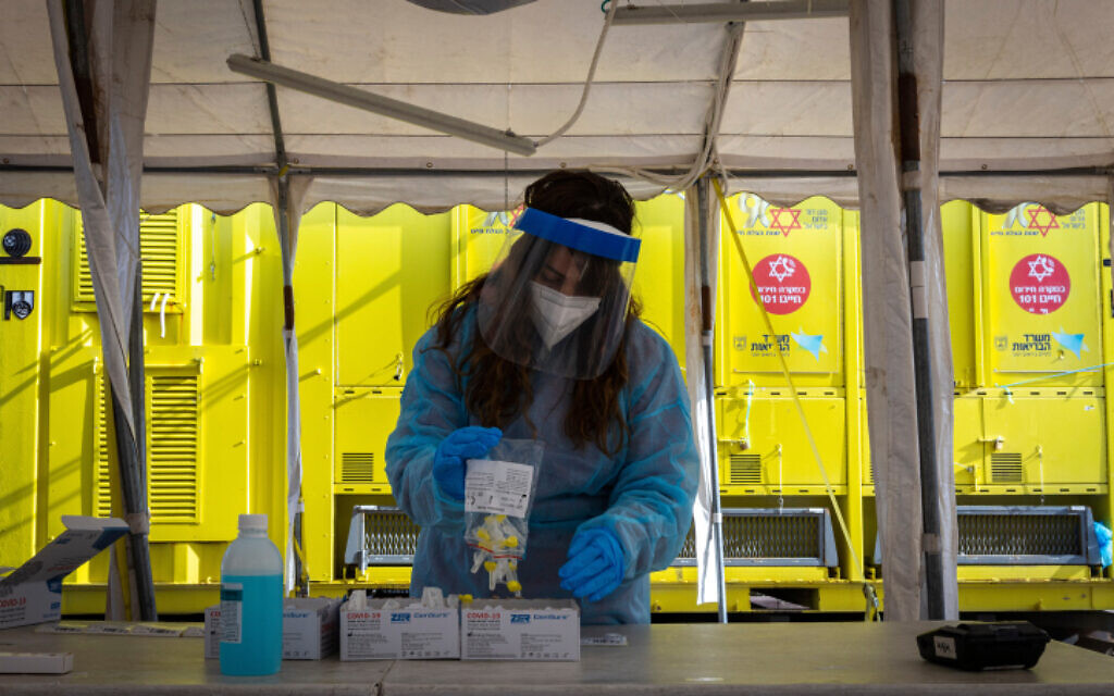 Une infirmière du Magen David Adom avec un test antigénique de dépistage rapide à la COVID-19 dans un centre de dépistage de type Drive-in à Jérusalem, le 22 mars 2022. (Crédit : Olivier Fitoussi/Flash90) Une infirmière du Magen David Adom avec un test antigénique de dépistage rapide à la COVID-19 dans un centre de dépistage de type Drive-in à Jérusalem, le 22 mars 2022. (Crédit : Olivier Fitoussi/Flash90)