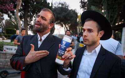 Des hommes ultra-orthodoxes assistent aux funérailles du policier Amir Khoury, tué dans une fusillade terroriste à Bnei Brak, au cimetière de Nof Hagalil, le 31 mars 2022. (Crédit : David Cohen/Flash90)
