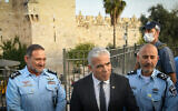 Le ministre des Affaires étrangères Yair Lapid, au centre, le commissaire de police Yaakov Shabtai et le commandant du district de Jérusalem Doron Turgeman à la porte de Damas, dans la Vieille Ville de Jérusalem, le 3 avril 3022. (Crédit : Arie Leib Abrams/Flash90)