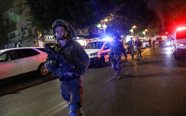Des soldats israéliens fouillent les lieux d'une attaque terroriste, dans laquelle deux personnes ont été tuées et plusieurs autres blessées, rue Dizengoff, au centre de Tel Aviv, le 7 avril 2022. (Crédit: Noam Revkin Fenton/Flash90)