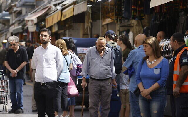 Des passants s’immobilisent, au marché Mahane Yehuda de Jérusalem, alors qu’une sirène de deux minutes retentit à travers Israël en hommage à la Journée de commémoration de la Shoah, le 28 avril 2022 (Crédit : Olivier Fitoussi/Flash90)