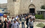 Des Palestiniens quittent la vieille ville par la porte de Damas après la prière du vendredi, le 8 avril 2022. (Crédit: Aaron Boxerman/Times of Israel)