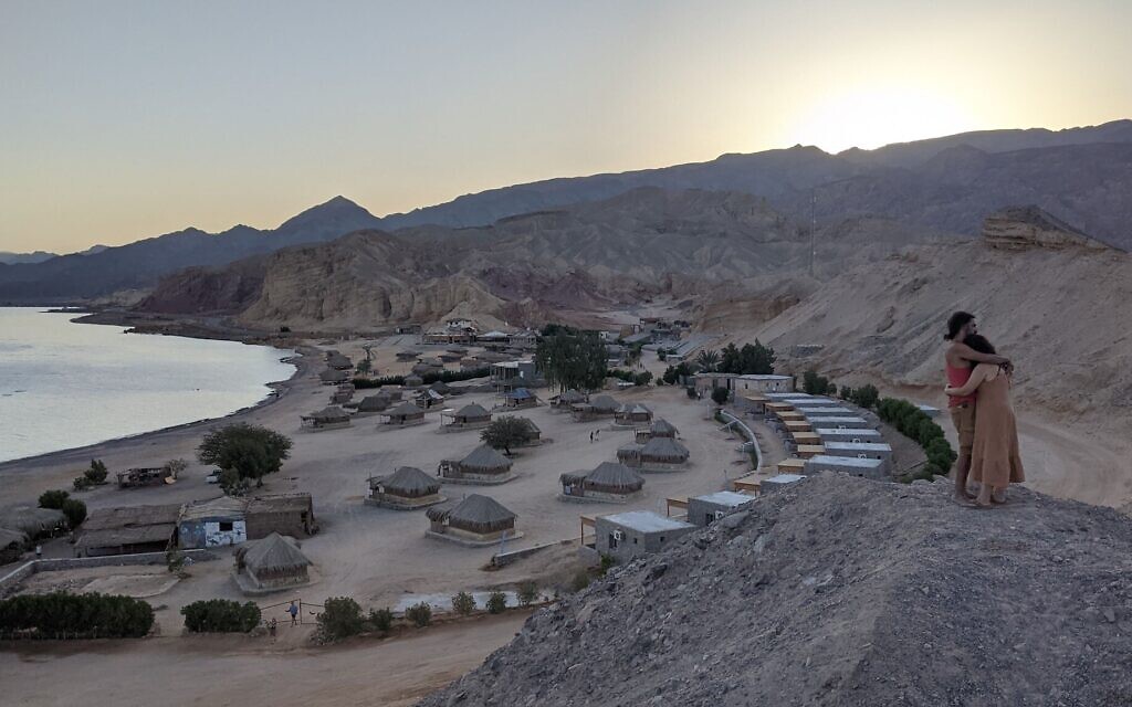 Un couple s'étreint au crépuscule au-dessus du Moon Island Camp à Ras Shaitan, dans le Sinaï, le 6 novembre 2021. (Crédit : Melanie Lidman/Times of Israel)