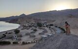 Un couple s'étreint au crépuscule au-dessus du Moon Island Camp à Ras Shaitan, dans le Sinaï, le 6 novembre 2021. (Crédit : Melanie Lidman/Times of Israel)