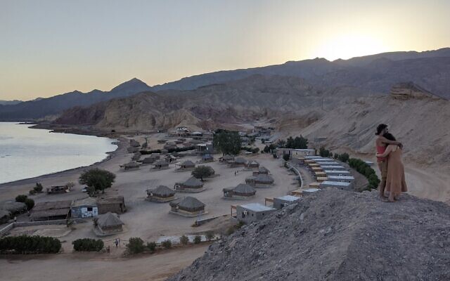 Un couple s'étreint au crépuscule au-dessus du Moon Island Camp à Ras Shaitan, dans le Sinaï, le 6 novembre 2021. (Crédit : Melanie Lidman/Times of Israel)