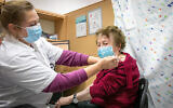 Une femme âgée reçoit une dose du vaccin contre la COVID-19 dans un centre de soins de santé temporaire de Maccabi à Rehovot, le 10 janvier 2022. (Crédit : Yossi Aloni/Flash90)