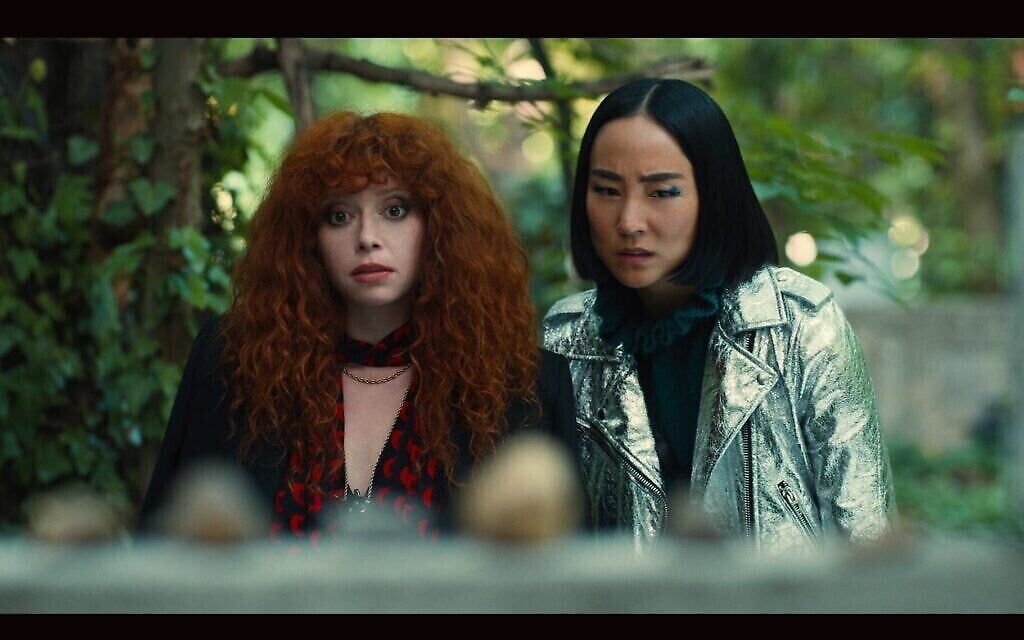 Nadia Vulvokov (Natasha Lyonne) et son amie Maxine (Greta Lee) trouvent la tombe d’un prêtre hongrois qui a sauvé les Juifs pendant la Shoah, dans la Saison 2 de "Russian Doll." (Crédit : Netflix via la JTA)
