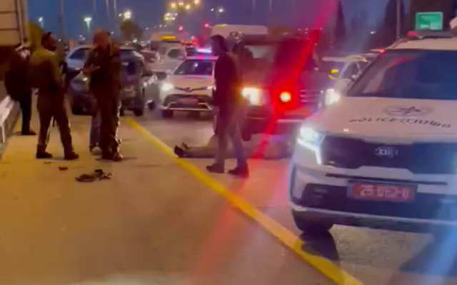 La police et les soldats se tiennent prêts du corps d'un homme qui se serait emparé de l'arme d'une soldate aux abords d'Ashkelon, le 10 avril 2022. (Capture d'écran : Twitter) La police et les soldats se tiennent prêts du corps d'un homme qui se serait emparé de l'arme d'une soldate aux abords d'Ashkelon, le 10 avril 2022. (Capture d'écran : Twitter)
