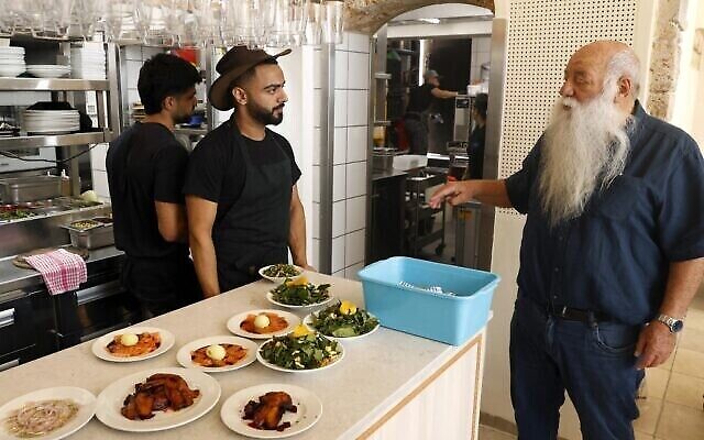 Le 2 mai 2022, le chef Uri Jeremias s’entretient avec des membres du personnel de son restaurant de fruits de mer et de poissons Uri Buri, dans la ville côtière d’Acre, au nord d’Israël (Crédit : Jack Guez/AFP)
