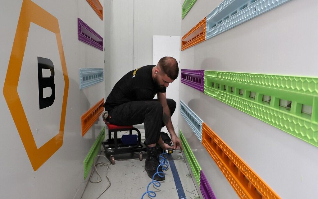 Un ingénieur installe de nouvelles ruches, dans le cadre du projet high-tech Beehome, dans le kibboutz israélien Bet Haemek, dans le nord de la Galilée, le 14 mai 2022. (Crédit : JACK GUEZ / AFP)