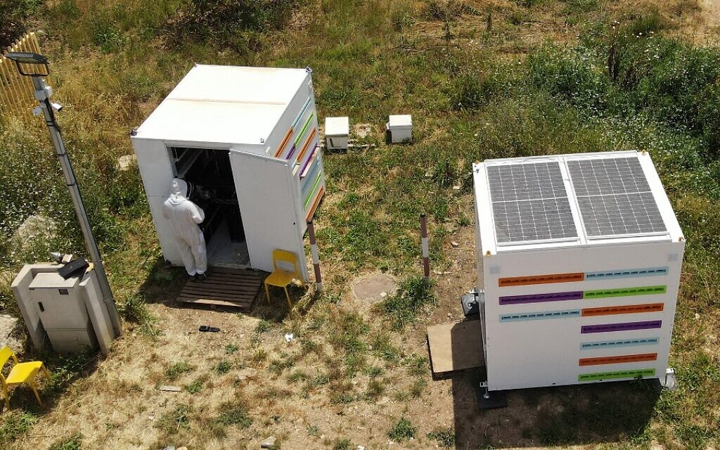 Un ingénieur installe de nouvelles ruches, dans le cadre du projet high-tech Beehome, dans le kibboutz israélien Bet Haemek, dans le nord de la Galilée, le 14 mai 2022. (Crédit : JACK GUEZ / AFP)
