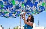 Maria Nissan, artiste et militante de l'environnement, photographiée avec l'une de ses installations artistiques créées à partir de déchets plastiques collectés dans les rues, dans la capitale jordanienne Amman, le 17 mai 2022. (Crédit : Khalil MAZRAAWI / AFP)