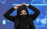 Une présentatrice de TOLOnews, Thamina Usmani, se couvre le visage pendant une émission en direct à la station de télévision Tolo à Kaboul, le 22 mai 2022. (Crédit : Wakil KOHSAR / AFP)
