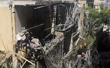 Dans la banlieue de Givatayim, à Tel Aviv, des Israéliens inspectent une maison endommagée le 12 mai 2021, touchée par une roquette tirée par des terroristes palestiniens depuis la bande de Gaza. (Crédit : Alexandra Vardi/AFP)