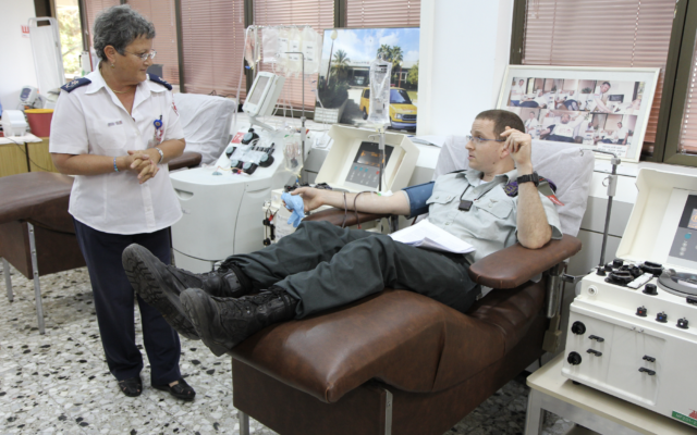 Le professeur Eilat Shinar, directeur des services sanguins du Magen David Adom, reçoit un don d'un Israélien. (Crédit : Autorisation Magen David Adom) Le professeur Eilat Shinar, directeur des services sanguins du Magen David Adom, reçoit un don d'un Israélien. (Crédit : Autorisation Magen David Adom)