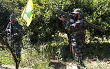 Un terroriste du Hezbollah tenant un missile anti-aérien de fabrication iranienne alors qu'il prend position avec son camarade entre des orangers, dans la ville frontalière côtière de Naqoura, au sud du Liban, le 20 avril 2017. (Crédit: Hussein Malla/AP)