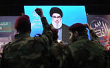 Dossier : Des combattants du Hezbollah lèvent le poing alors que leur chef Hassan Nasrallah s'exprime via une liaison vidéo lors d'un rassemblement pour marquer la journée de Jérusalem ou journée Al-Quds, dans la banlieue sud de Beyrouth, au Liban, le 29 avril 2022. (Crédit : AP Photo/Hassan Ammar)