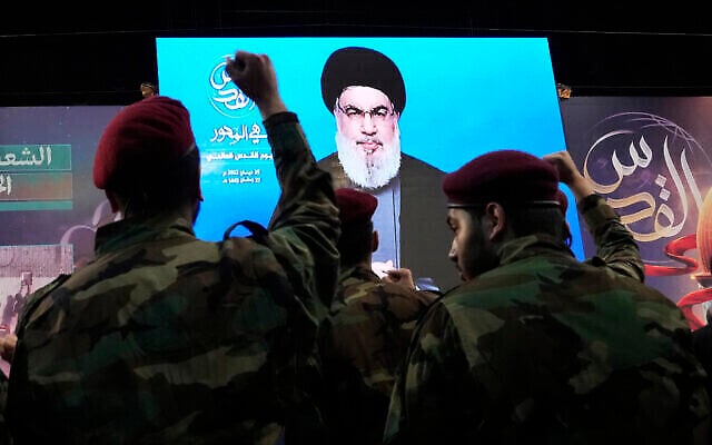Dossier : Des combattants du Hezbollah lèvent le poing alors que leur chef Hassan Nasrallah s'exprime via une liaison vidéo lors d'un rassemblement pour marquer la journée de Jérusalem ou journée Al-Quds, dans la banlieue sud de Beyrouth, au Liban, le 29 avril 2022. (Crédit : AP Photo/Hassan Ammar) Dossier : Des combattants du Hezbollah lèvent le poing alors que leur chef Hassan Nasrallah s'exprime via une liaison vidéo lors d'un rassemblement pour marquer la journée de Jérusalem ou journée Al-Quds, dans la banlieue sud de Beyrouth, au Liban, le 29 avril 2022. (Crédit : AP Photo/Hassan Ammar)