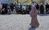 Une Afghane attend de recevoir des rations alimentaires distribuées par un groupe d’aide humanitaire saoudien, à Kaboul, en Afghanistan, le lundi 25 avril 2022. (Crédit : AP Photo/Ebrahim Noroozi)