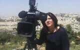 Sur cette photo non datée, la journaliste d' Al Jazeera pose avec une caméra avec la Vieille Ville de Jérusalem en arrière-plan. (Crédit : Al Jazeera Media Network via AP)