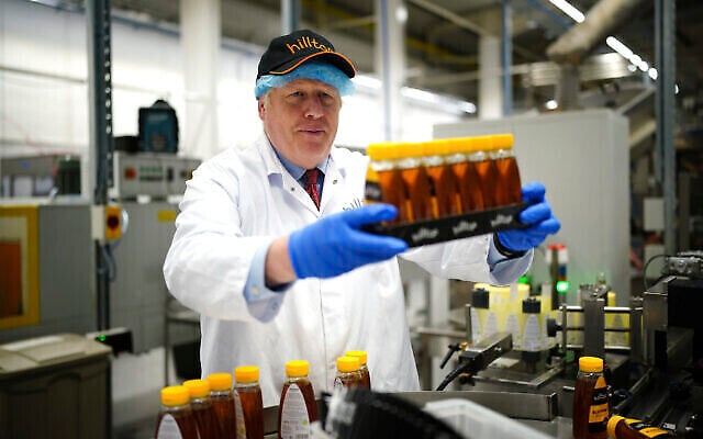 Le Premier ministre britannique, Boris Johnson, lors d’une visite à Hilltop Honey à Newtown, Powys, dans le Pays de Galles, le 20 mai 2022. (Crédit : Ben Birchall/Pool via AP) Le Premier ministre britannique, Boris Johnson, lors d’une visite à Hilltop Honey à Newtown, Powys, dans le Pays de Galles, le 20 mai 2022. (Crédit : Ben Birchall/Pool via AP)