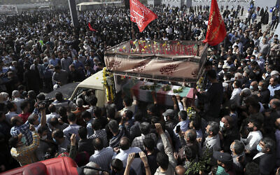 Des personnes en deuil se rassemblent autour d'un camion transportant le cercueil drapé du drapeau du colonel Hassan Sayyad Khodaei, des Gardiens de la révolution iraniens, tué dimanche, lors de la cérémonie funéraire à Téhéran, en Iran, le 24 mai 2022. (Crédit : Vahid Salemi/AP)
