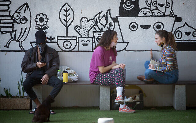 Des Israéliens savourent un café à emporter à Tel-Aviv, après un troisième confinement en raison de la pandémie de COVID-19, en avril 2021. (Crédit : Miriam Alster/Flash90)