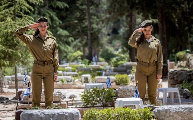 Des soldats israéliens devant les tombes de soldats morts au combat au cimetière militaire du Mont Herzl à Jérusalem, le 2 mai 2022. (Crédit : Yonatan Sindel/Flash90) Des soldats israéliens devant les tombes de soldats morts au combat au cimetière militaire du Mont Herzl à Jérusalem, le 2 mai 2022. (Crédit : Yonatan Sindel/Flash90)