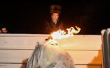 Le grand rabbin de la dynastie Boyan allumant un feu de joie  pendant les célébrations de Lag BaOmer, sur le mont Meron, le 18 mai 2022. (Crédit : David Cohen/Flash90)