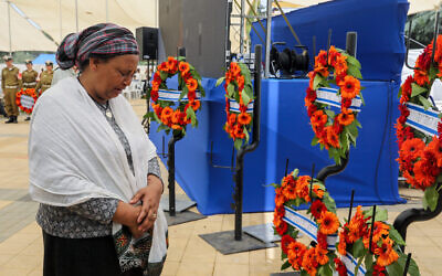 Une femme pleurant devant des couronnes de fleurs lors d'une cérémonie en l'honneur des milliers de Juifs éthiopiens morts en route vers Israël entre 1979 et 1990, au cimetière du Mont Herzl à Jérusalem, le 29 mai 2022. (Crédit: Marc Israel Sellem/Pool)