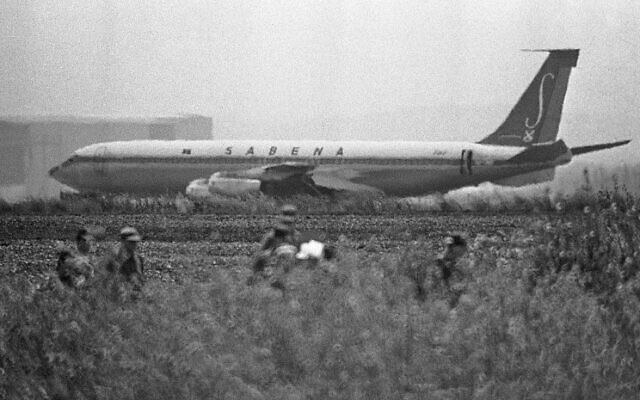 Dans cette photo du 15 mai 1972, les soldats israéliens patrouillent dans les champs autour de la piste 26 où l’avion détourné de Sabena est cloué au sol, à l’aéroport international de Lod. (Crédit : AP Photo)