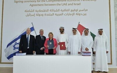 La ministre israélienne de l'Économie et de l'Industrie Orna Barbivai signe un accord de libre-échange avec les Émirats arabes unis à Dubaï, le 31 mai 2022. De gauche à droite : Ohad Cohen, directeur de l'administration du commerce extérieur au ministère de l'Économie et de l'Industrie ; l'ambassadeur israélien aux EAU Amir Hayek, la ministre israélienne de l'Économie et de l'Industrie Orna Barbibai ; le ministre de l'Économie émirati Abdulla bin Touq Al-Marri, le ministre d'État émirati au Commerce extérieur Thani bin Ahmed Al Zeyoudi ; l'ambassadeur émirati en Israël  Mohamed Al Khaja et Juma Al Kait,  directeur de l'administration émiratie du commerce extérieur. (Crédit : Anuj Taylor, Strap Studios)