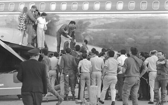 Les forces de l'ordre aident les passagers et l’équipage du vol 571 de Sabena, après son détournement de 1972 à l’aéroport de Lod (Crédit : Ron Ilan/Israël Defense Forces Archive)