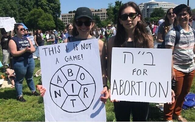 Deux femmes brandissent des panneaux lors de la manifestation organisée en faveur du droit à l'adoption par le groupe NCJW (National Council of Jewish Women) à Washington, le 17 mai 2022. (Crédit : Julia Gergely)
