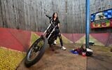 Karmila Purba, "princesse du mur de la mort", avec sa moto avant une représentation à Bogor, le 30 avril 2022. Pendant des décennies, le « Tube de Satan » a été la principale attraction des fêtes foraines itinérantes en Indonésie, en particulier dans les zones rurales où il existe peu d'options de divertissement abordables. (Crédit : ADEK BERRY / AFP)