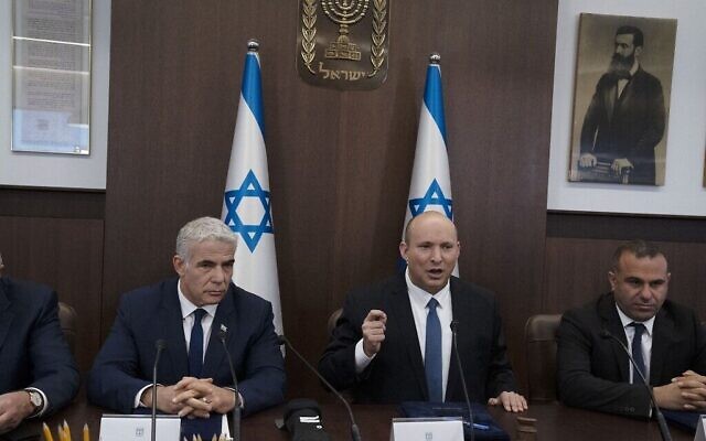 Le Premier ministre Naftali Bennett, au centre, et le ministre des Affaires étrangères Yair Lapid, à gauche, lors de la réunion hebdomadaire du cabinet à Jérusalem, le 12 juin 2022. (Crédit: Maya Alleruzzo / POOL / AFP)