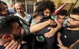 Des proches en deuil lors des funérailles du Palestinien Ali Harb, qui, selon les Palestiniens, aurait été tué par un résident d'implantation israélien dans le village d'Iskaka, dans le nord de la Cisjordanie, le 22 juin 2022 (Crédit: Jaafar Ashtiyeh / AFP).